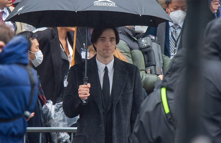 بروس وین با چتری در دست پس از شرکت در مراسم تدفین فیلم The Batman