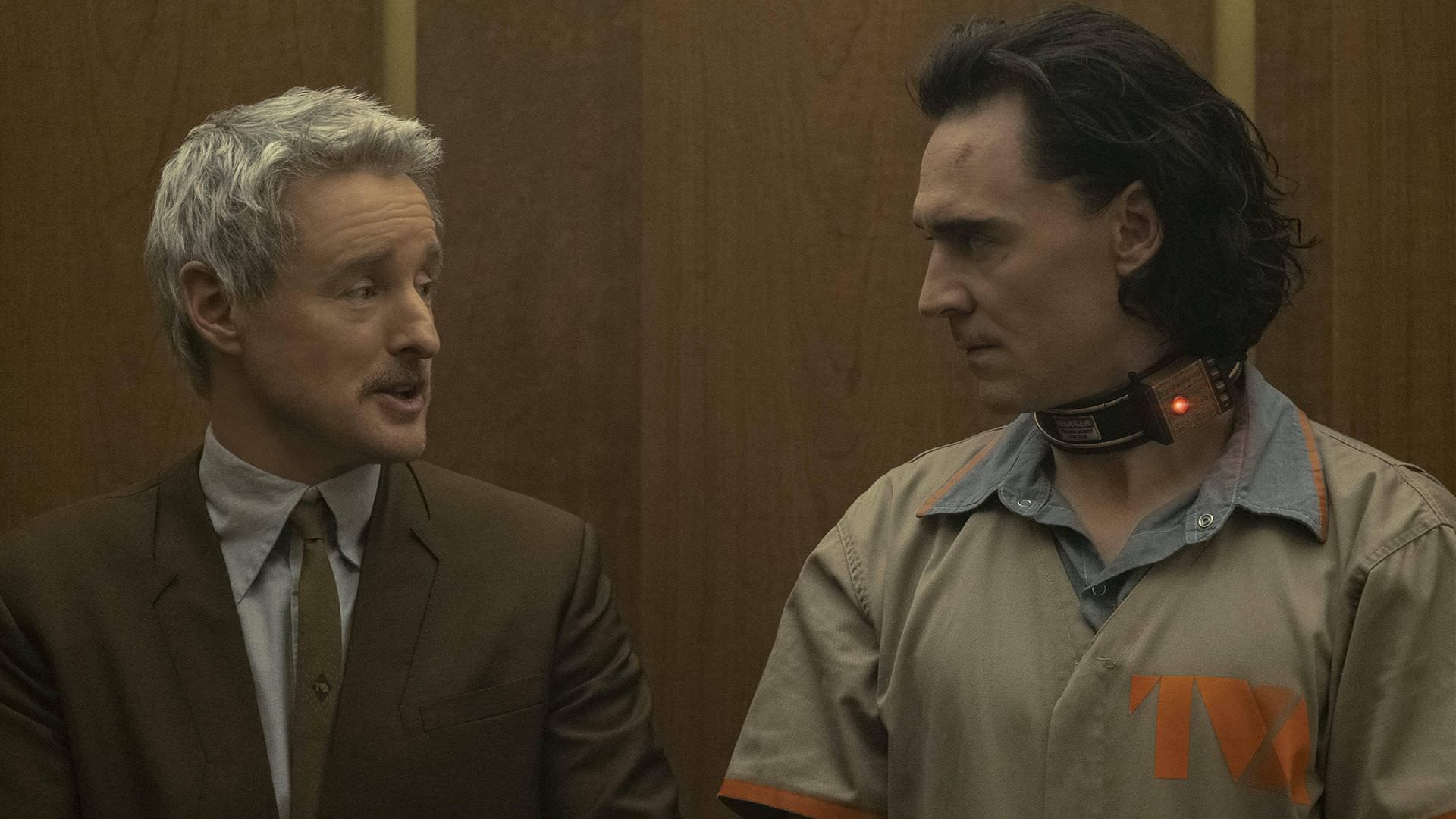 تام هیدلستون در نقش لوکی و اوون ویلسون در نقش ایجنت موبیوس در حال حرف زدن در آسانسور در ساختمان TVA در قسمت اول سریال Loki